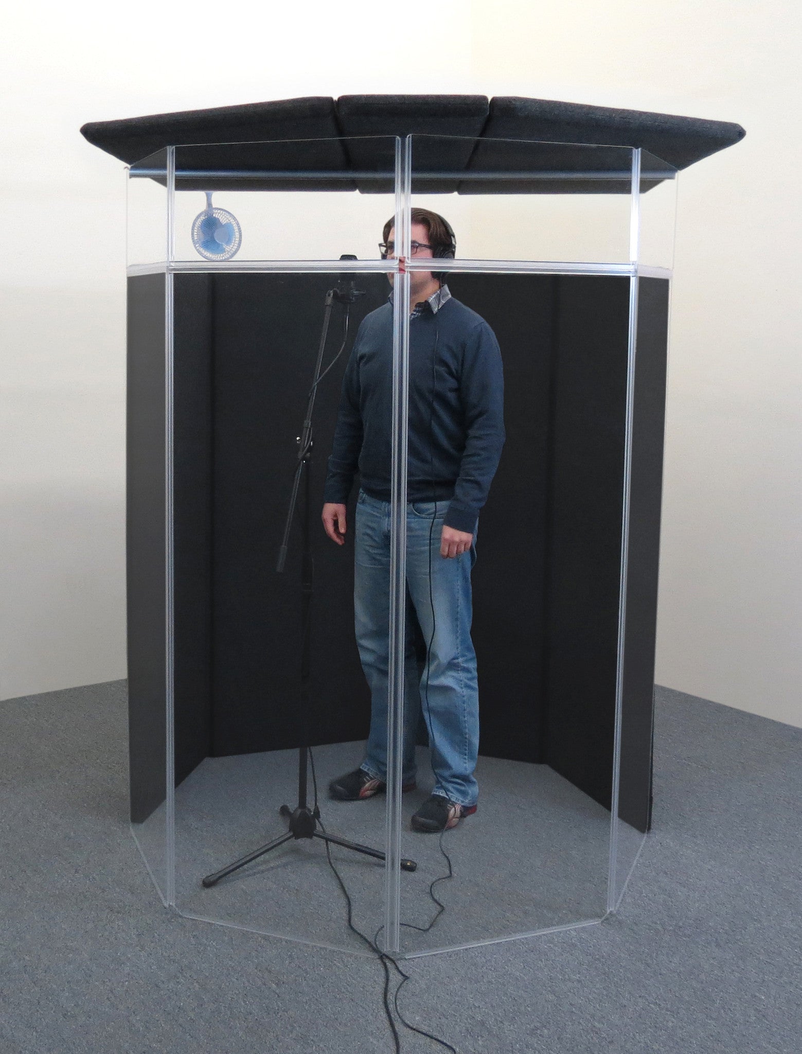 A person recording voice-overs inside an IsoPac F vocal booth.